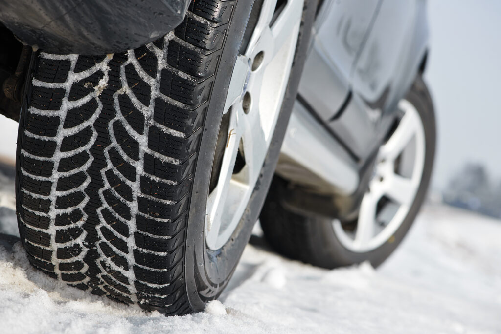 Car with winter tyres installed on light alloy wheels in snowy o